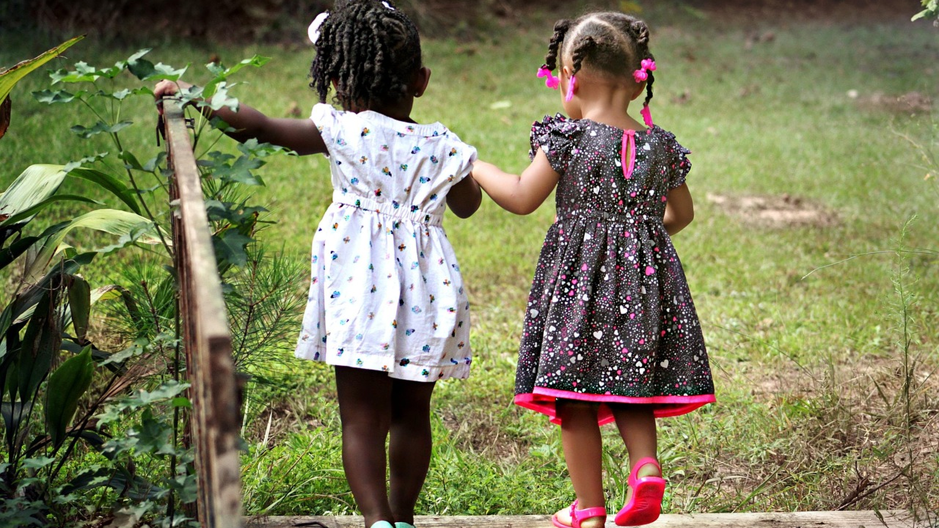 Two young friends walking close together outside as the end of school year lice surge begins