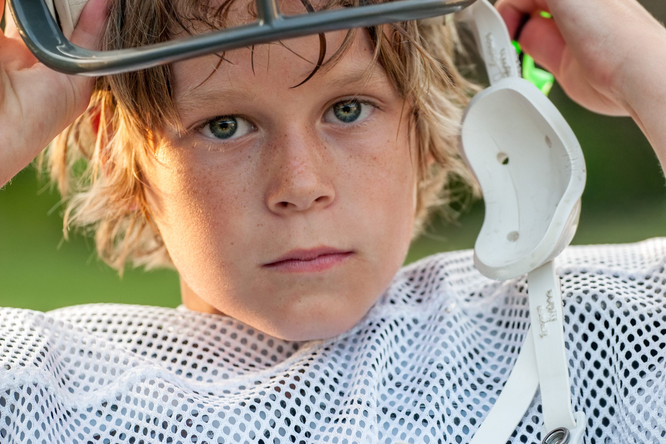Young boy taking his football helmet off