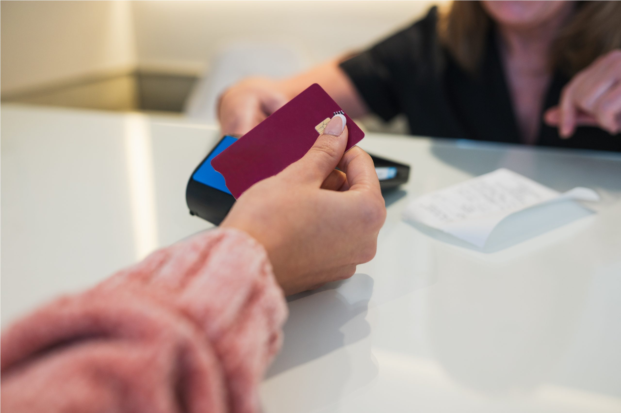 Customer paying a clinic bill with a card, illustrating eligible lice treatment payment with FSA or HSA funds