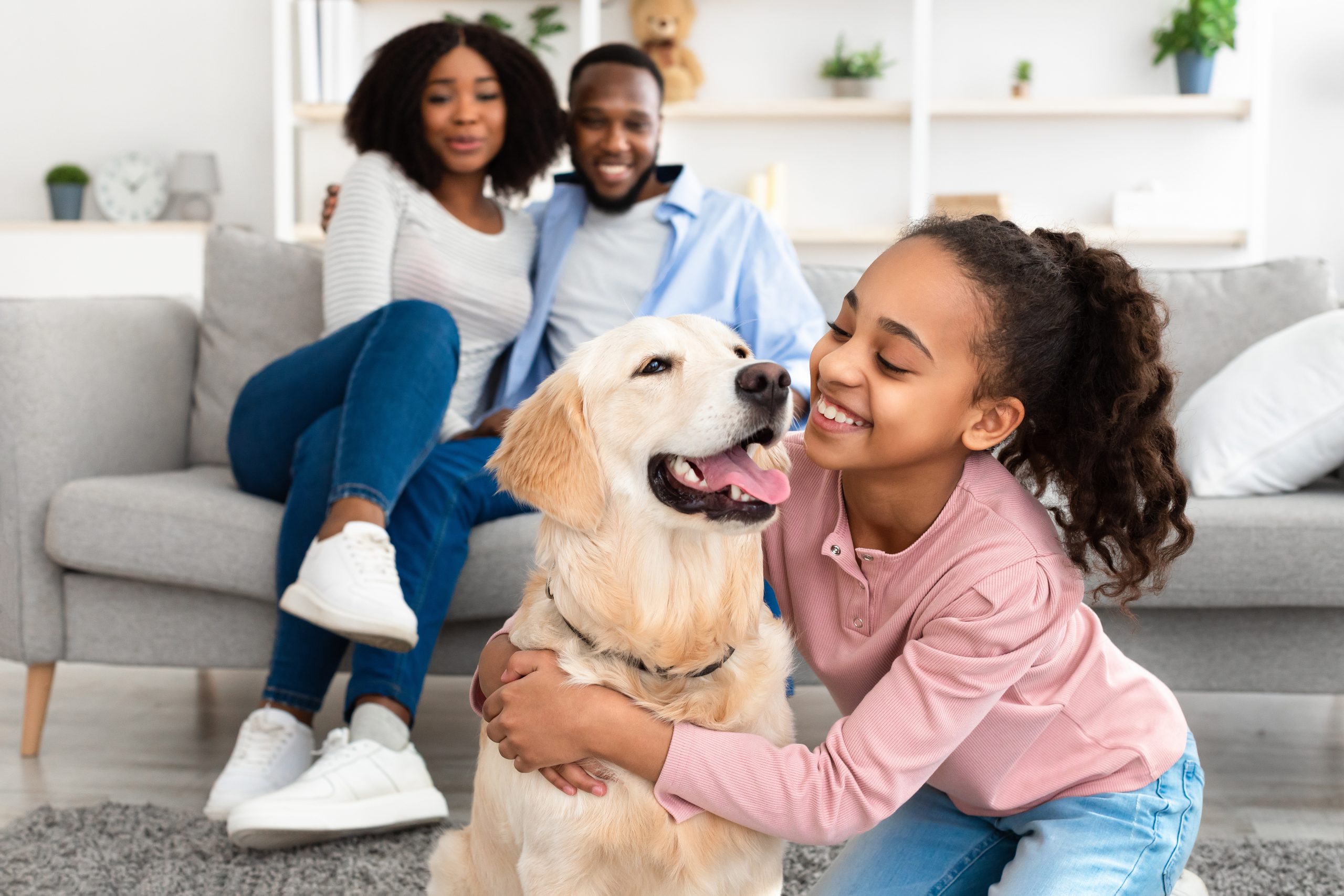 Family at home with a child hugging a dog, illustrating the pet question in head lice guidance